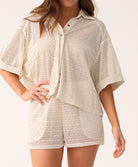 Woman wearing a beige textured shirt and shorts set on a white background