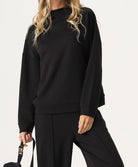 Woman wearing a black outfit with a plain background