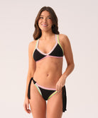 Woman wearing a black bikini with colorful trim on a white background