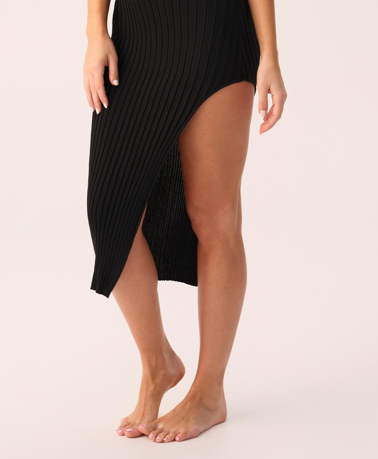 Black ribbed dress with a slit on a white background