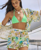 A woman wearing a matching floral shirt and shorts standing outside on a boat.