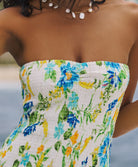 A woman wearing a strapless dress with a floral pattern.