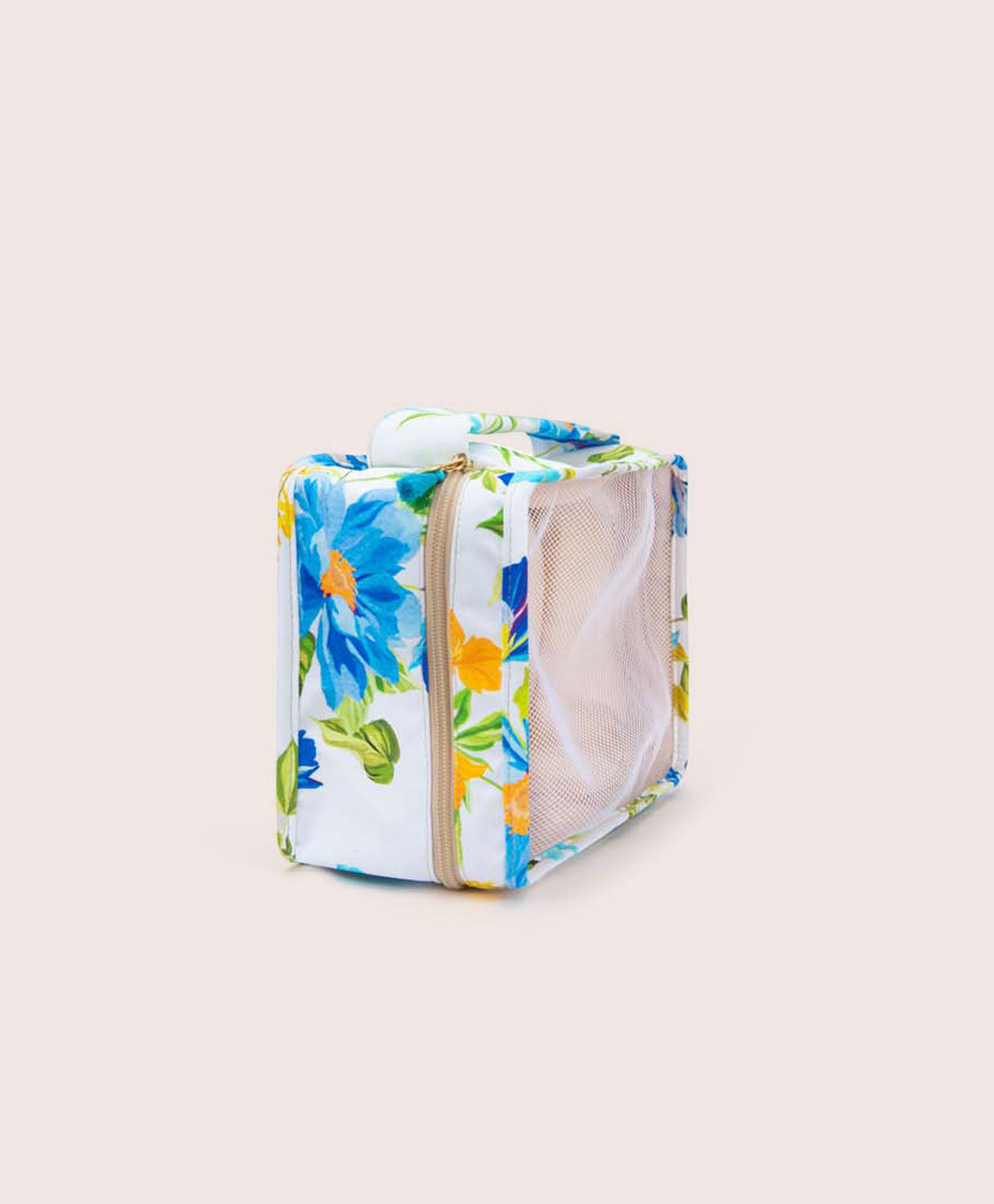 A packing cube with a floral print against a white wall.