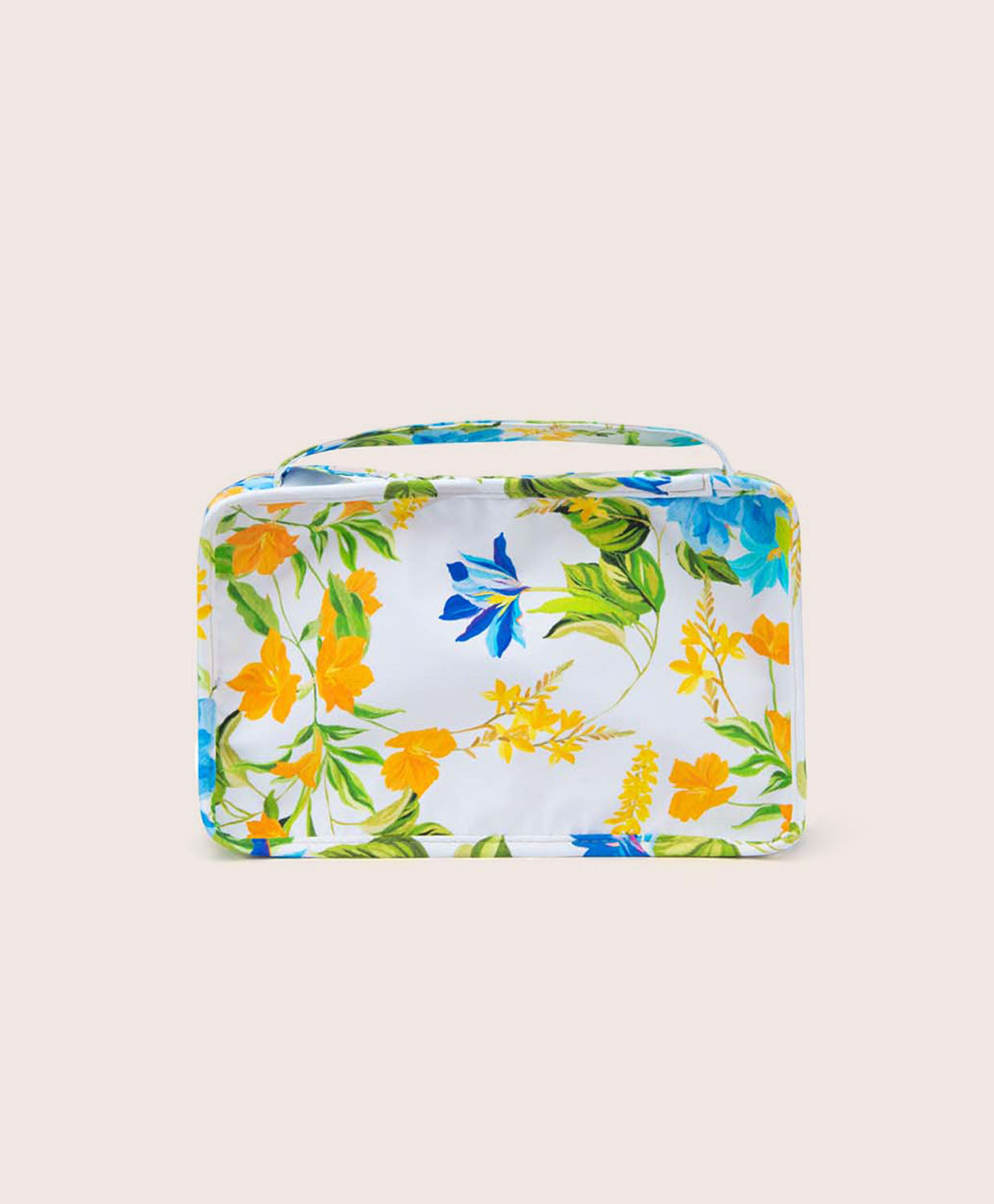 A packing cube with a floral print against a white wall.