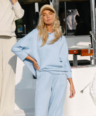Woman in light blue outfit standing on a boat