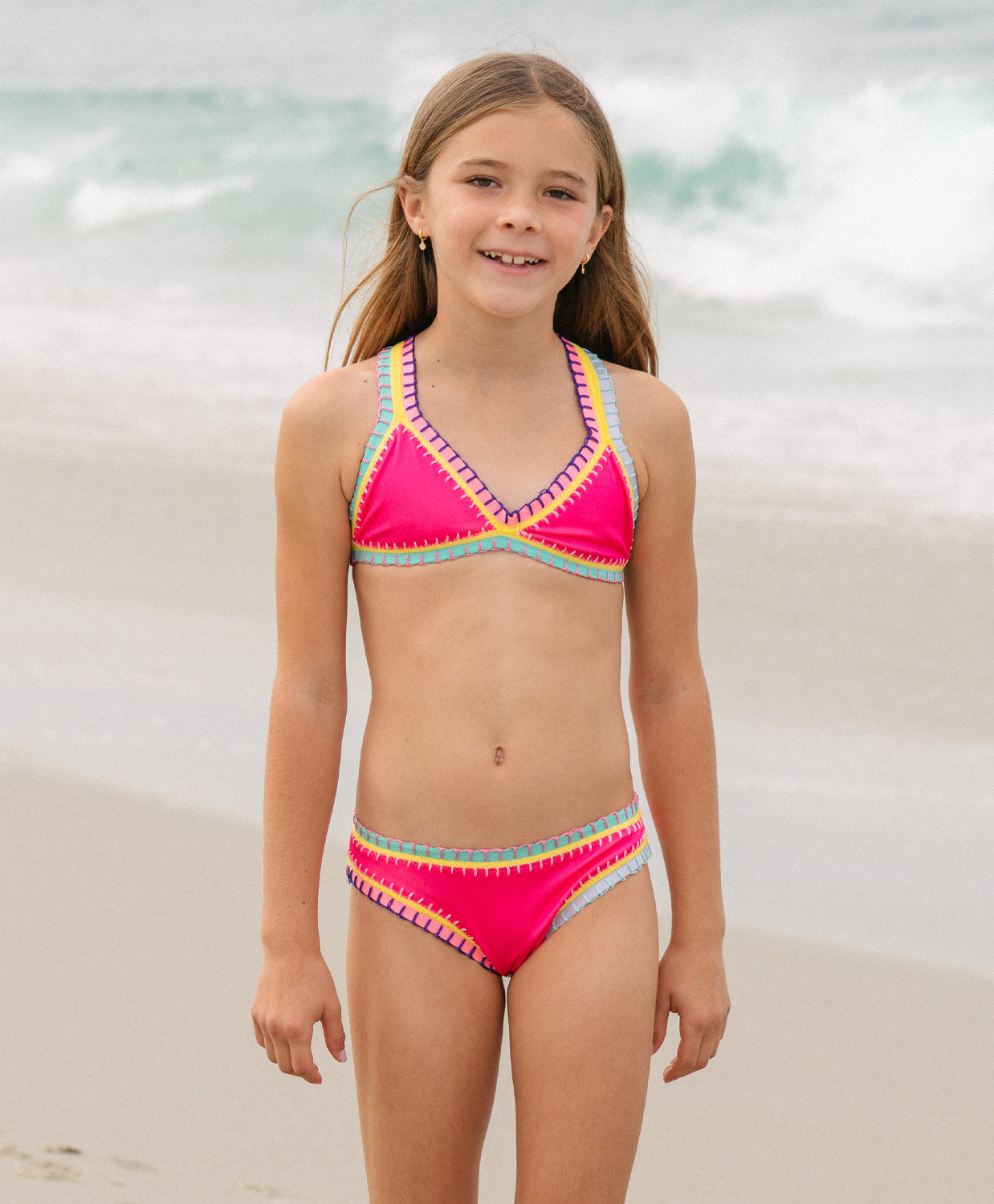 Young girl wearing a colorful bikini set on a beach