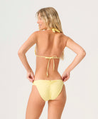 Woman wearing a yellow bikini against a plain background
