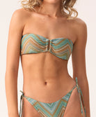 Woman wearing a strapless patterned bikini set on a plain background