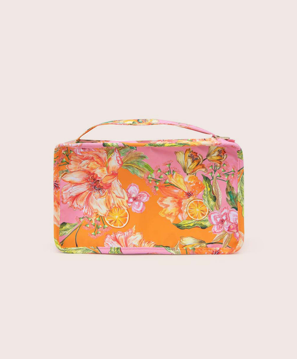 A packing cube with an orange floral print against a white wall.