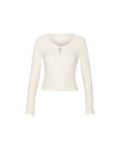 A cream long-sleeve cropped knit top with a scoop neckline and a small keyhole cutout at the center chest, displayed on a solid white background.