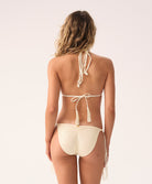 Woman wearing a cream bikini with a white background