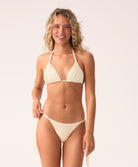 Woman wearing a cream bikini against a white background