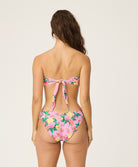 Woman wearing a floral bikini set on a plain background