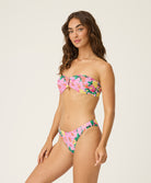 Woman wearing a floral bikini set on a plain background