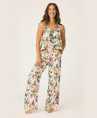 Woman wearing a floral pajama set on a plain background