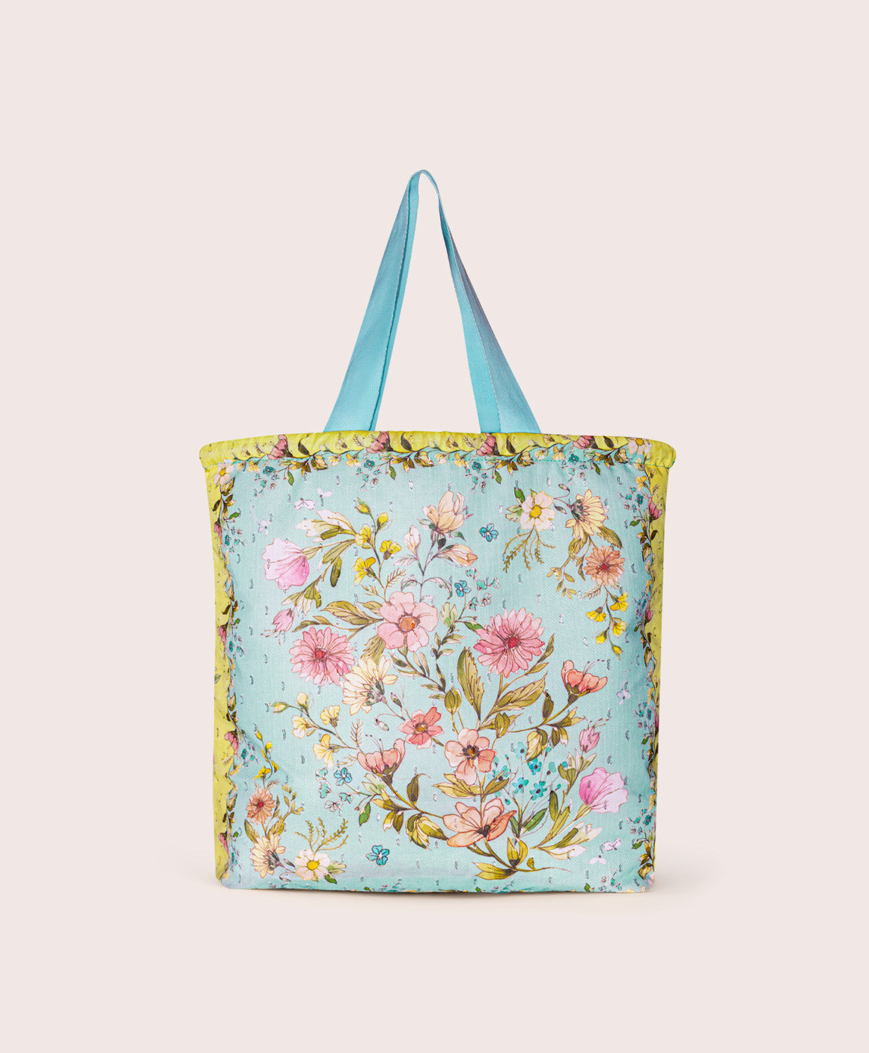Floral tote bag with blue straps on a plain background
