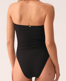 Woman wearing a black strapless swimsuit on a white background