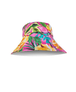 A pink tropical pattern reversible bucket hat.  Featured against a white wall background.