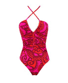 A pink & red one piece swim suit against a white wall.