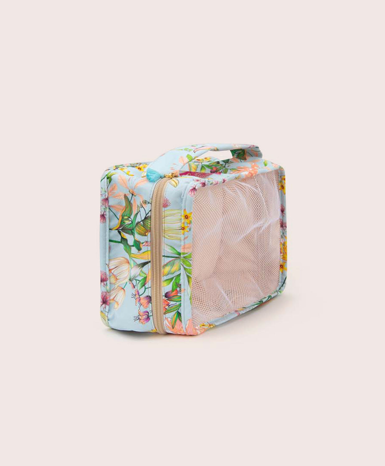 A packing cube with blue floral fabric against a white wall.