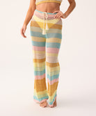 Pastel striped crochet pants worn by a woman on a white background