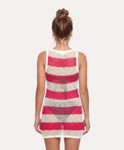 Woman wearing a sleeveless dress with pink and beige striped pattern on a white background