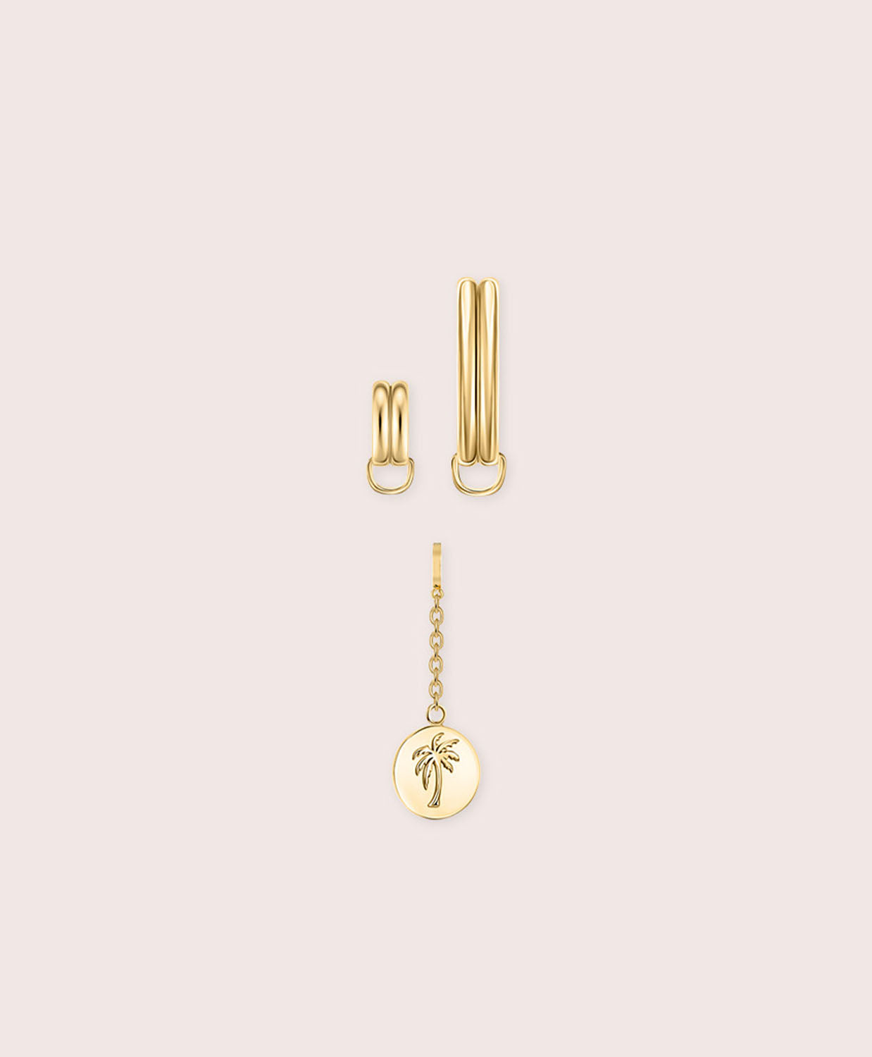 Gold jewelry piece with palm tree details against a white wall.