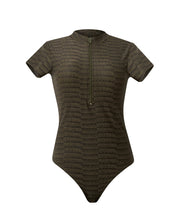 A textured gray one piece swimsuit with zipper detail. Featured against a white wall background.