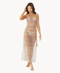 Brunette woman wearing a multi-colored sleeveless lace tunic with open side slits and lace-up side details with tassel tie ends over a matching bikini stands in front of white wall.