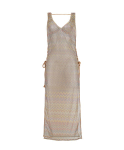 A multi-colored sleeveless lace tunic with open side slits and lace-up side details with tassel tie ends. Featured against a white wall background.