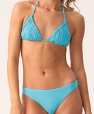 Woman wearing a blue bikini set on a plain background