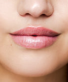 Close up shot of a woman wearing pink lip gloss.