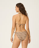 Woman wearing a leopard print bikini on a white background