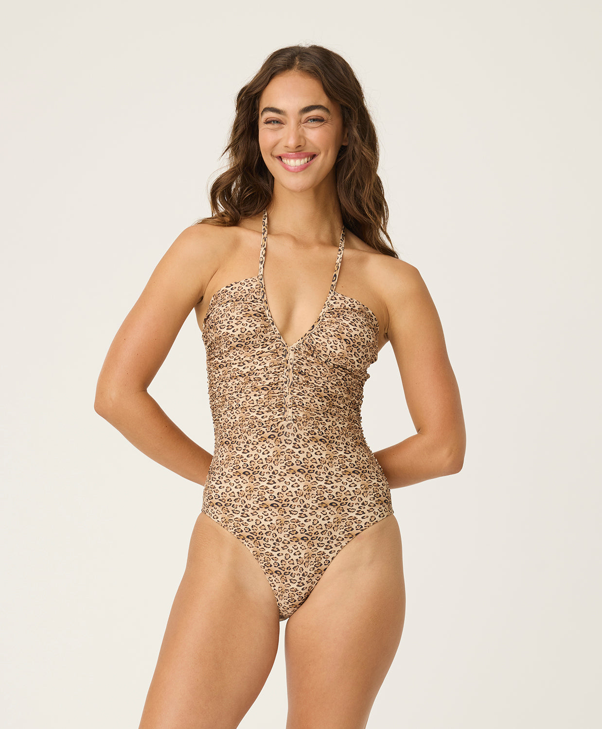 Woman wearing a leopard print swimsuit on a plain background