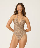 Woman wearing a leopard print swimsuit on a plain background