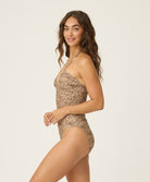 Woman wearing a leopard swimsuit against a white background