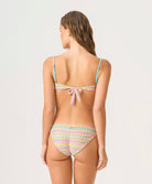 Woman wearing a colorful bikini with a white background