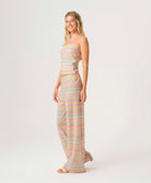 Woman wearing a pastel striped outfit on a white background