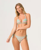 Woman wearing a colorful bikini with a zigzag pattern on a white background