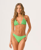 Woman wearing a green triangle bikini against a white background