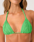 Green bikini top worn by a woman on a white background