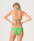 Green bikini set worn by a model on a light gray background