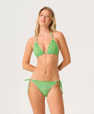 Woman wearing a green lace bikini against a white background