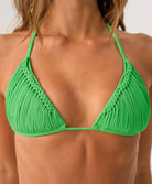 Green bikini top with macrame details on a person against a neutral background