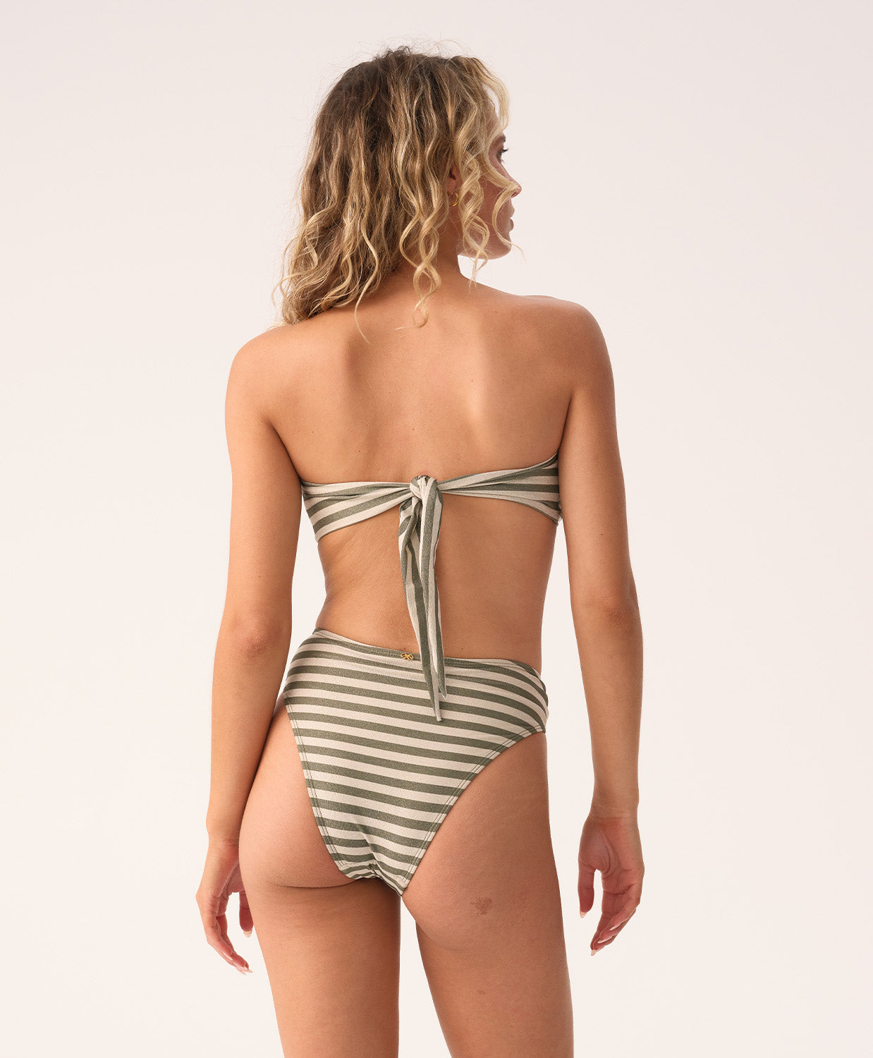 Woman wearing a striped swimsuit on a plain background