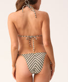 Woman wearing a striped bikini on a plain background