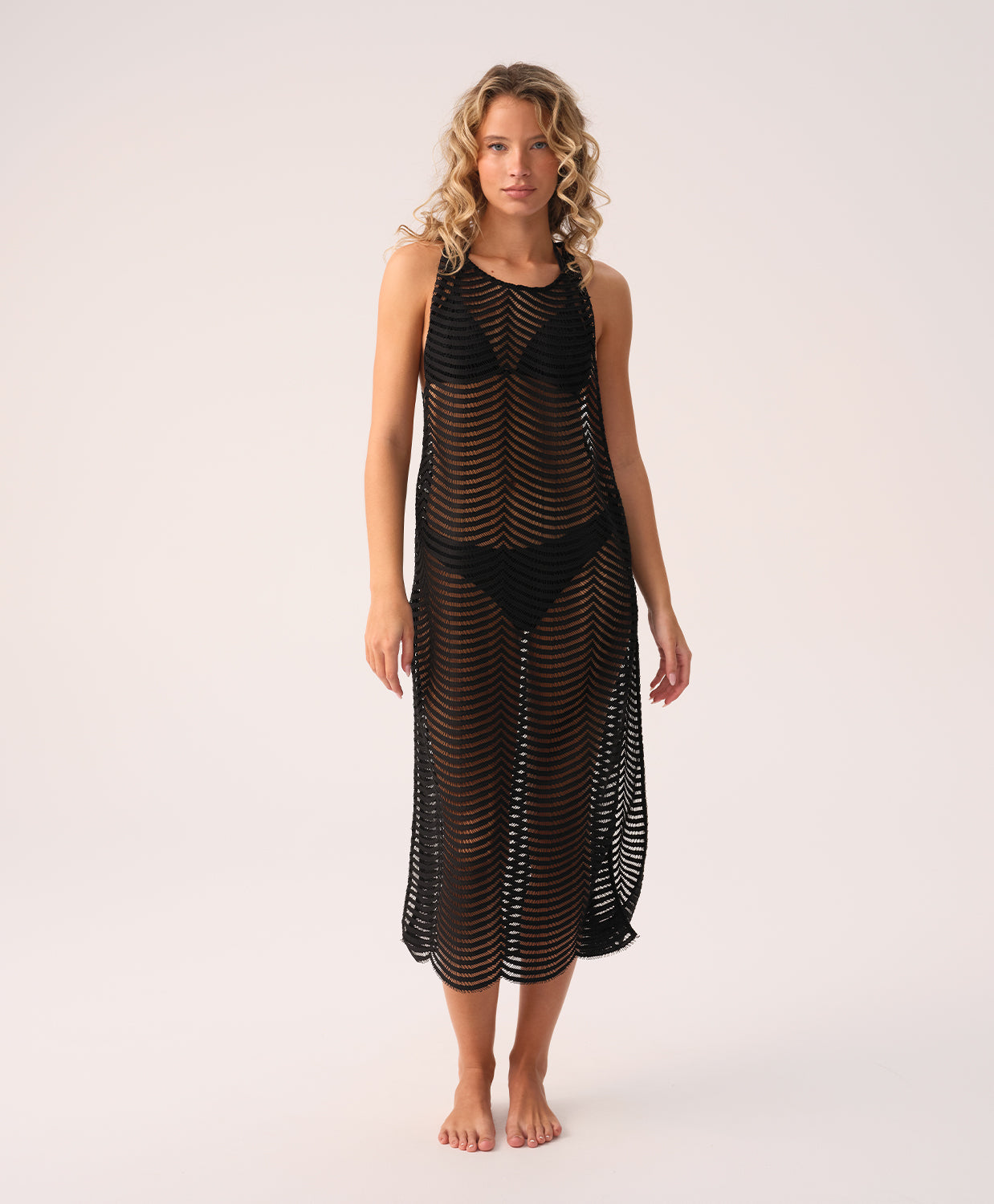 Woman wearing a black mesh dress on a white background