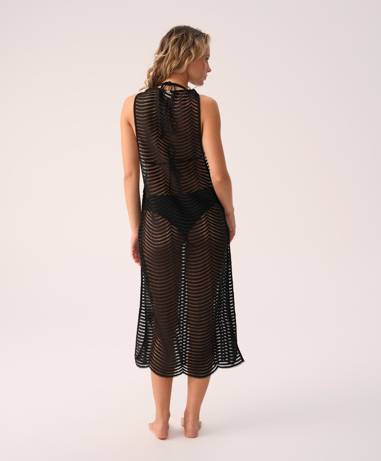 Woman wearing a black mesh dress on a white background