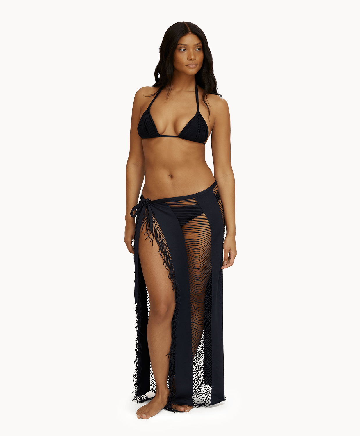 Woman wearing black sarong in front of a white background. 