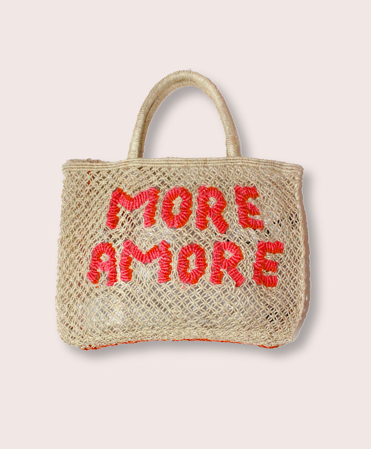 A purse/tote that says "More Amore" in pink letters against a white wall.